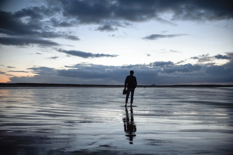 a man walking on top of the water during sunset