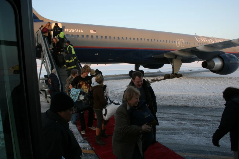 a group of people boarding an airplane from the tarmac