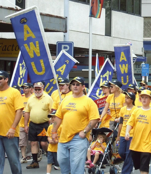 a large group of people walk down the street carrying flags