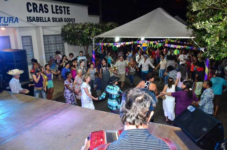 people are dancing on a dance floor with tables in the background