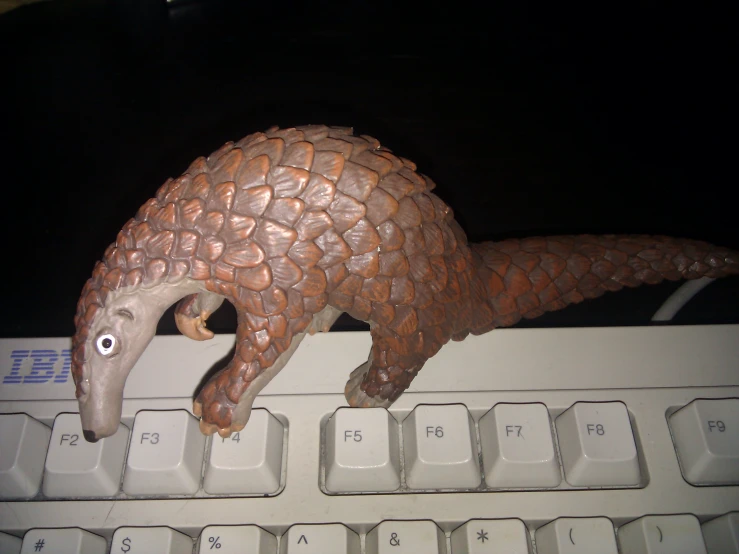 a sculpture of an alligator on top of a computer keyboard