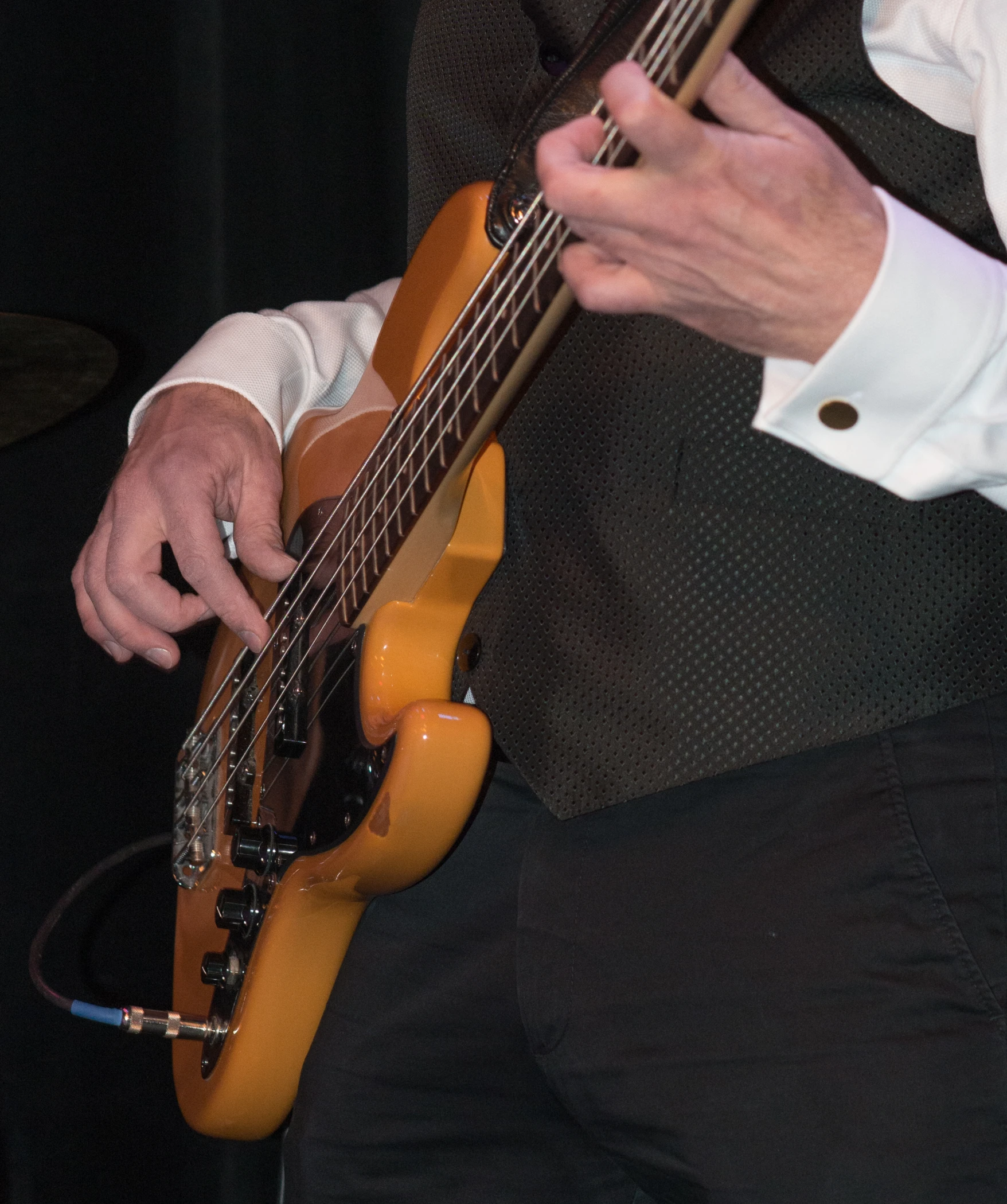 man playing bass guitar close up on stage