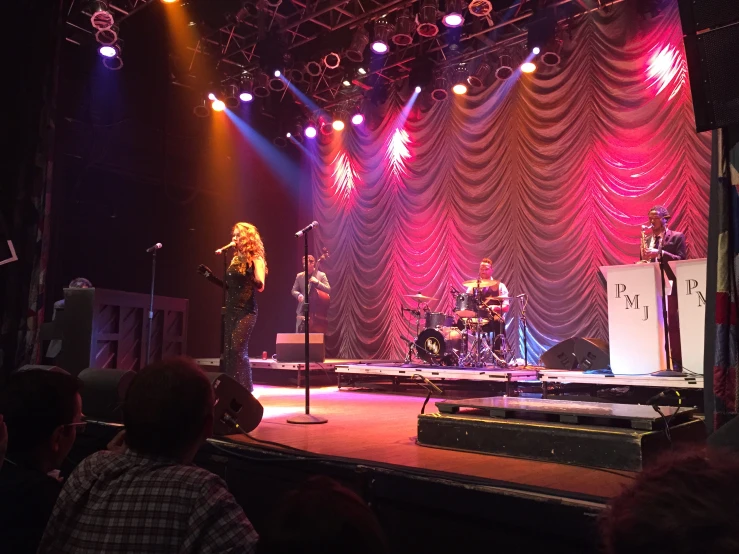 a man and woman standing on stage with microphones in front of them