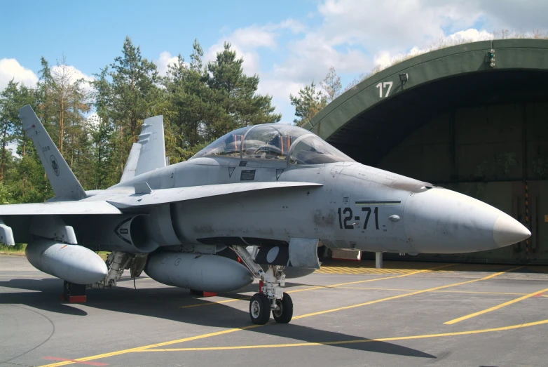 an airplane sitting parked at the airport with one man looking inside