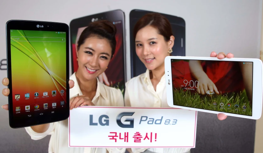 an asian woman holds up two new lg pada - 2 tablets