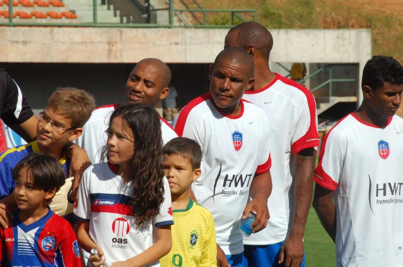 young children stand together in a soccer field