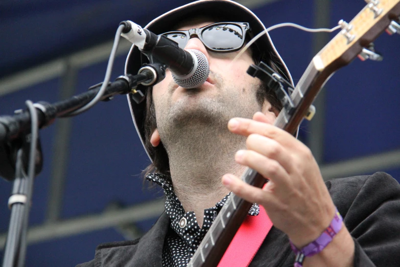 a man singing while playing a guitar