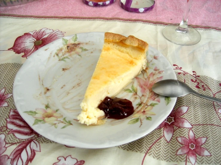 a piece of cheesecake with a side of jam on the plate