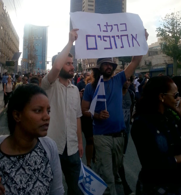 two protesters holding up placards in the street