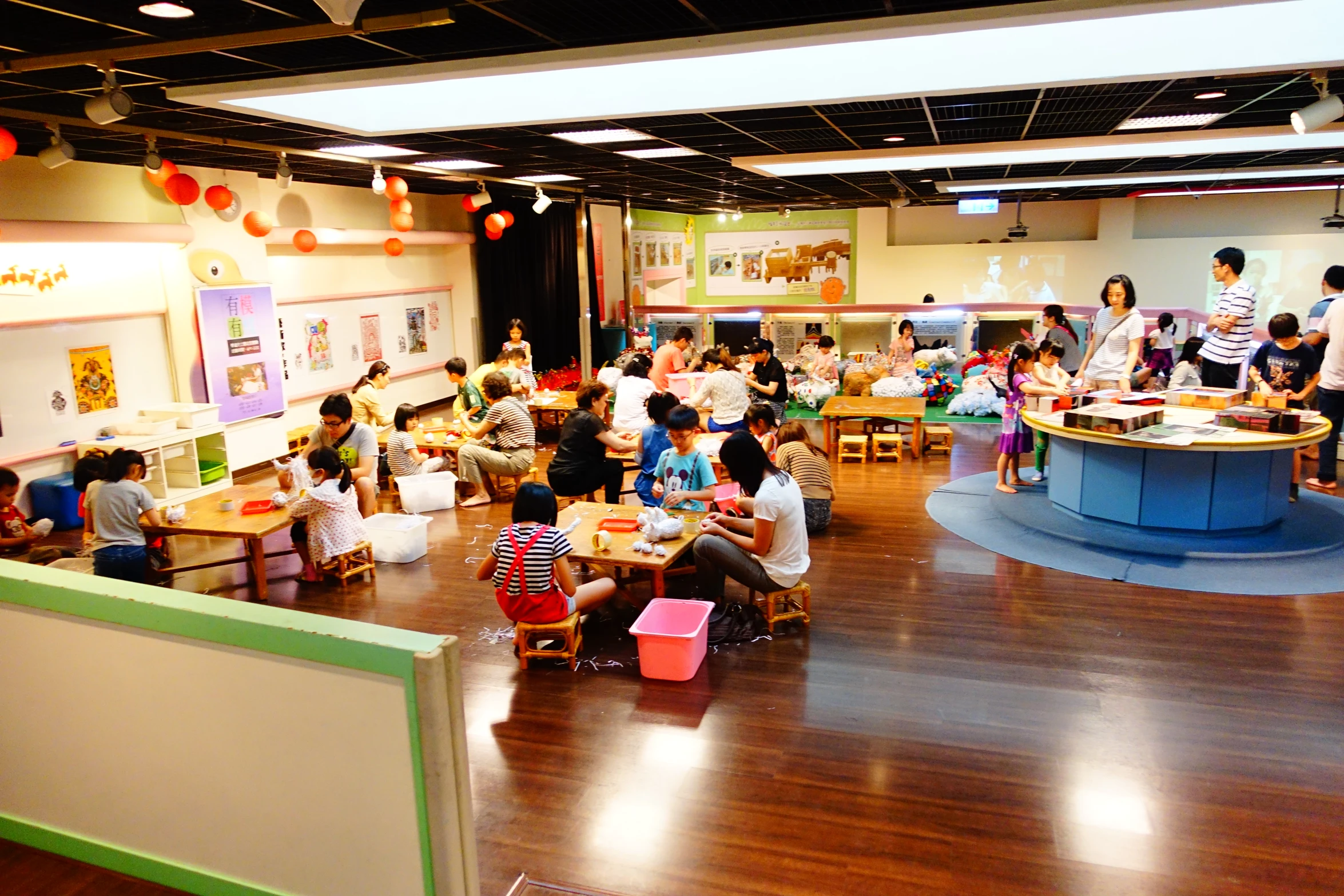 a room filled with s and adults sitting around eating