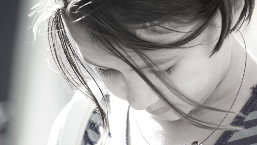 a young woman wearing a necklace next to her cell phone