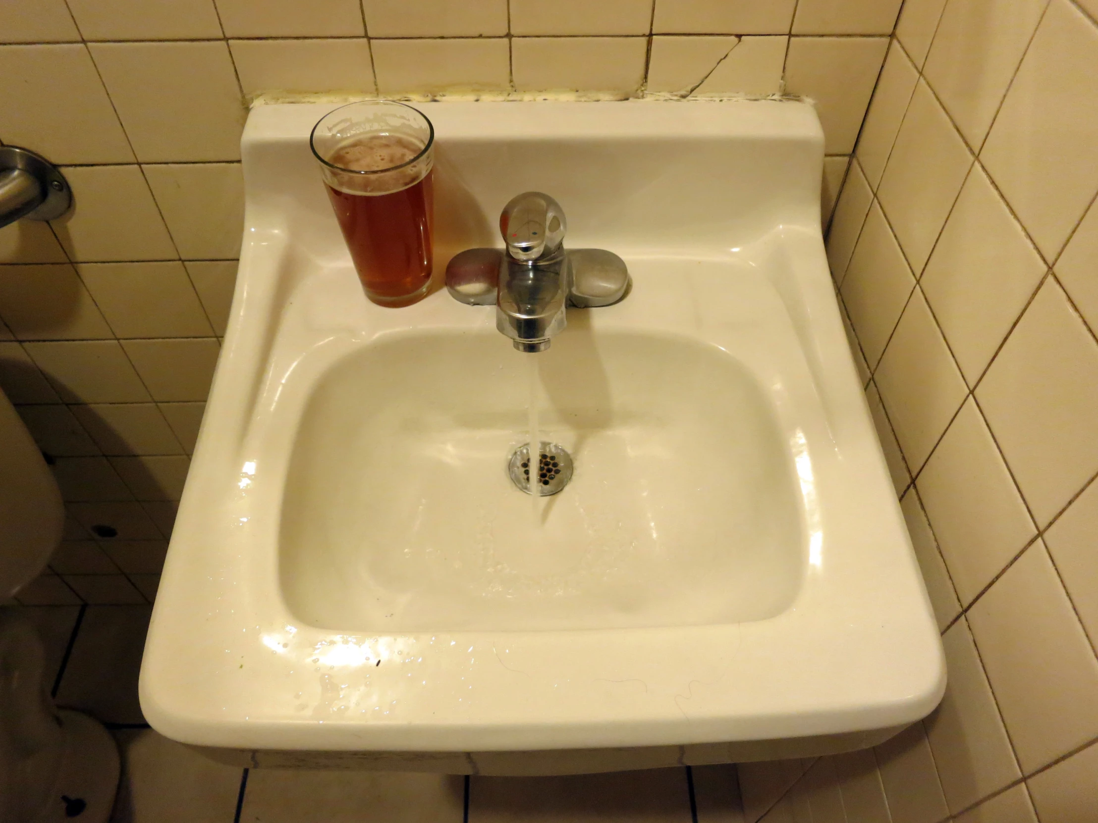 an old white porcelain sink and soap dispenser with soap