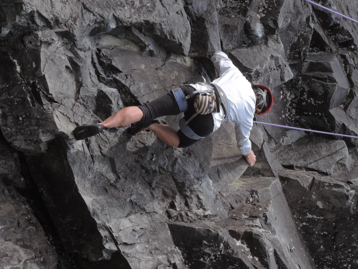 a man standing on top of a mountain while he is climbing