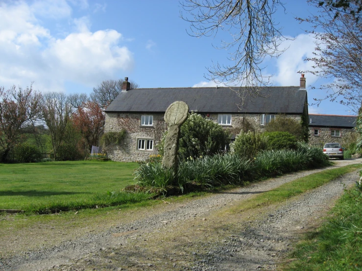 the house is sitting behind a stone sculpture