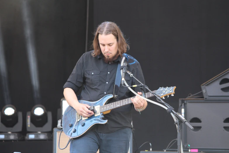 a man that is standing up with a guitar