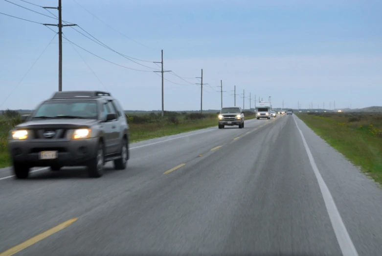 two cars driving down the road in one direction