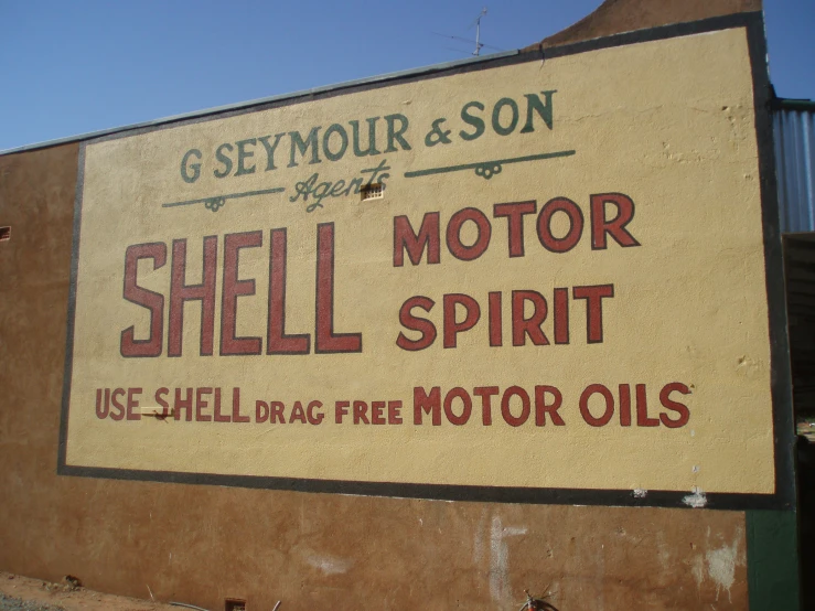 a sign advertising motor spirit sits on a building