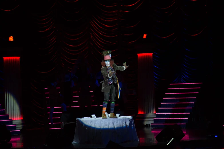 a circus performer dressed as the mad hatter on stage