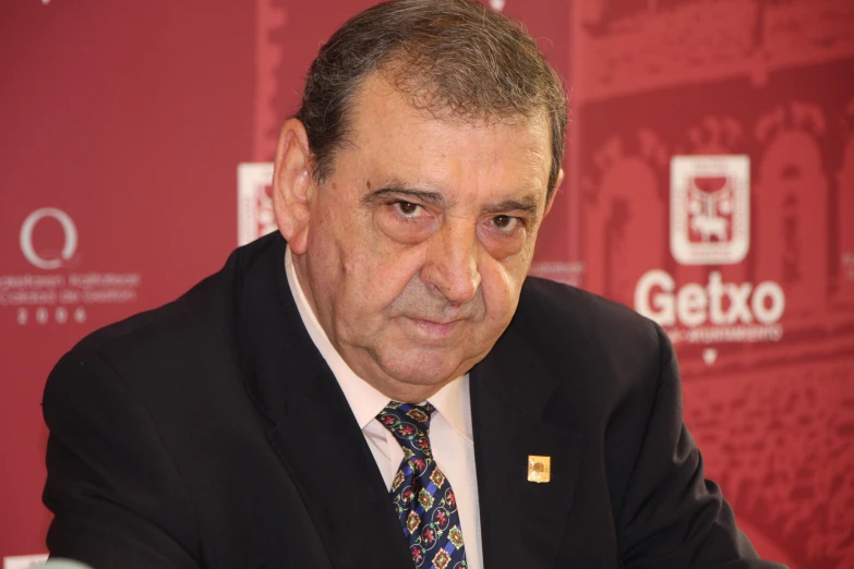 a man wearing a black suit and colorful tie