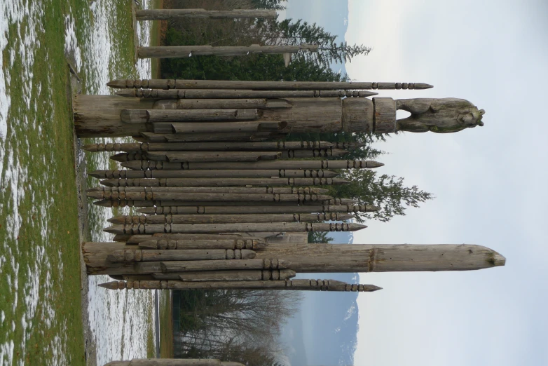 this is a sculpture consisting of rocks that are stacked in the grass and standing on ice