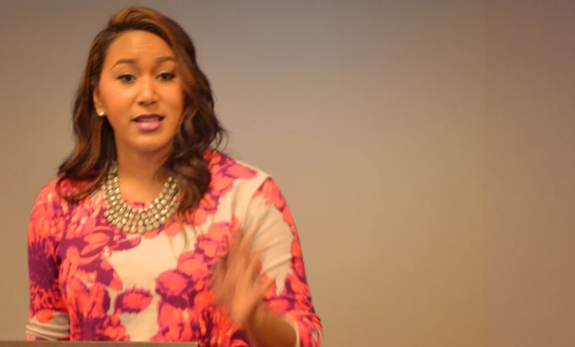 a woman speaking with an audience in a conference room