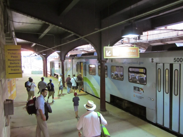 people walking along side a train at the platform