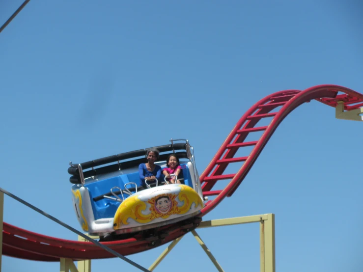 the two girls are riding on the roller coaster