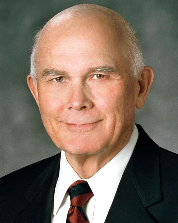 a man wearing a red tie and a black suit