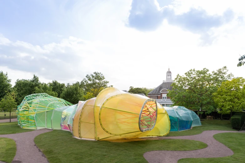 large kite shaped like houses on grass in park