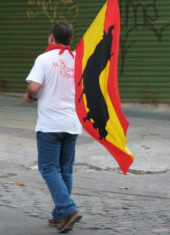 a man carries a large red and yellow flag