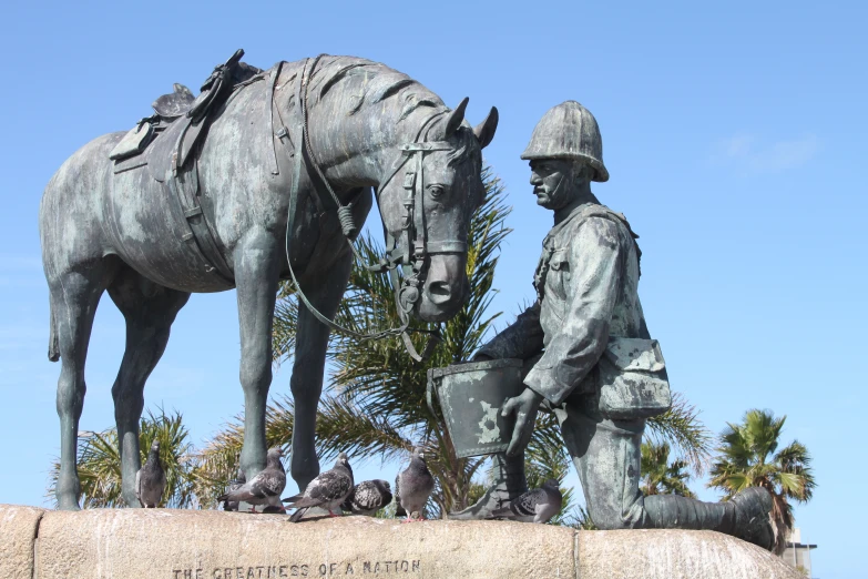 a statue of a man sitting on top of a horse next to another sculpture