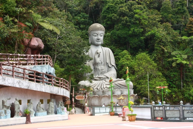 a large white buddha statue surrounded by trees