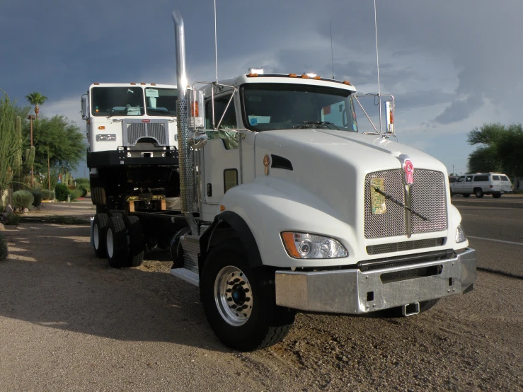 two semi trucks parked in a parking lot next to each other