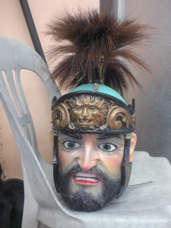 a face sitting on a chair with a feather on its head