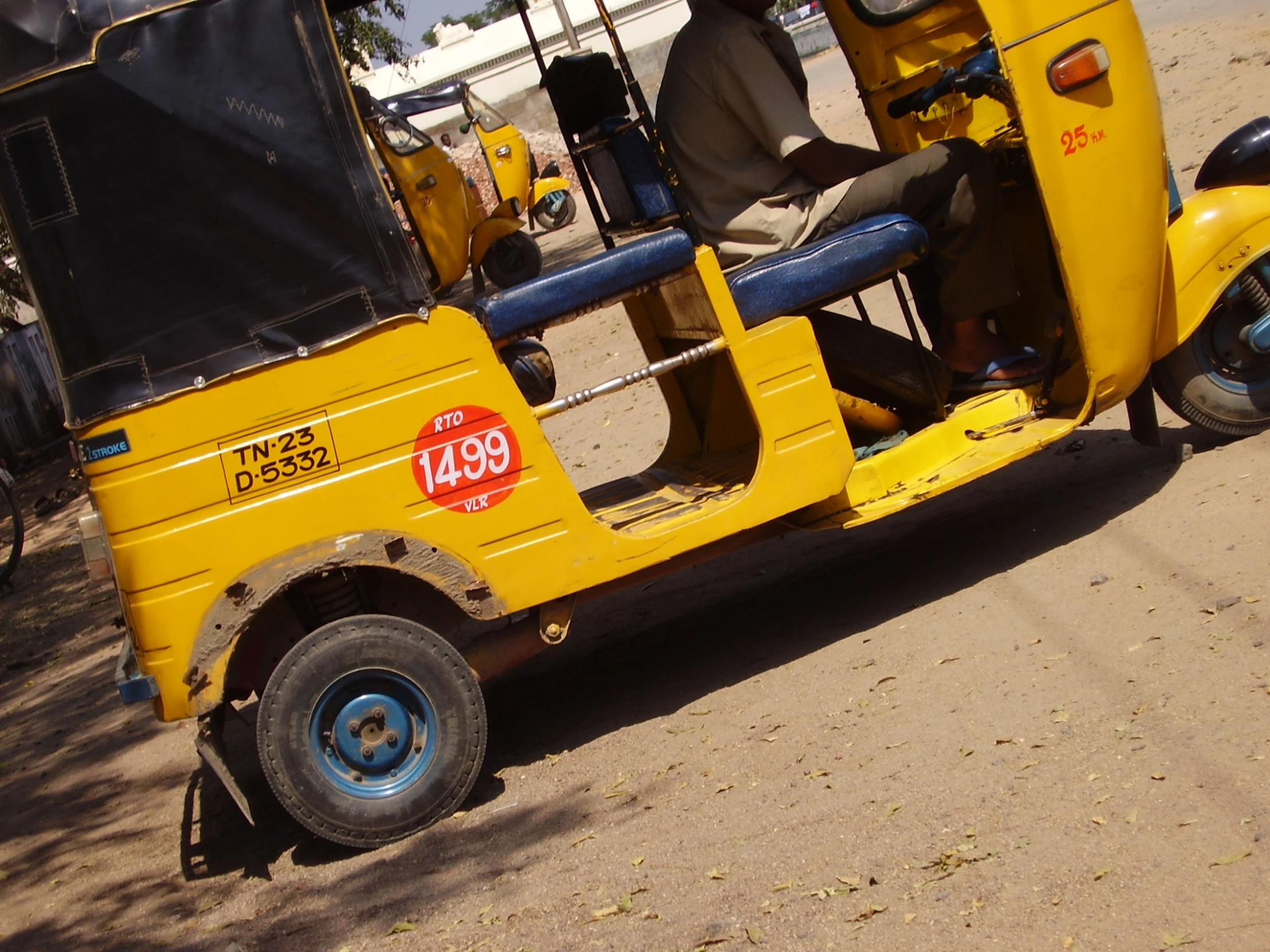 yellow three wheel motor vehicle sitting in the sun