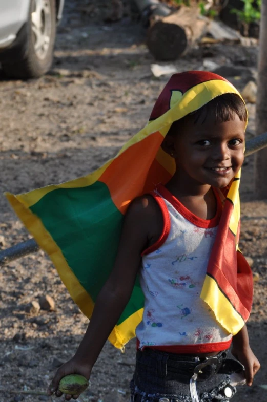 a little boy that is standing on a dirt ground