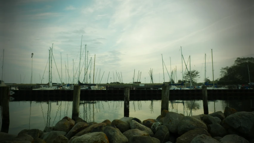 many boats are docked in a harbor with rocks