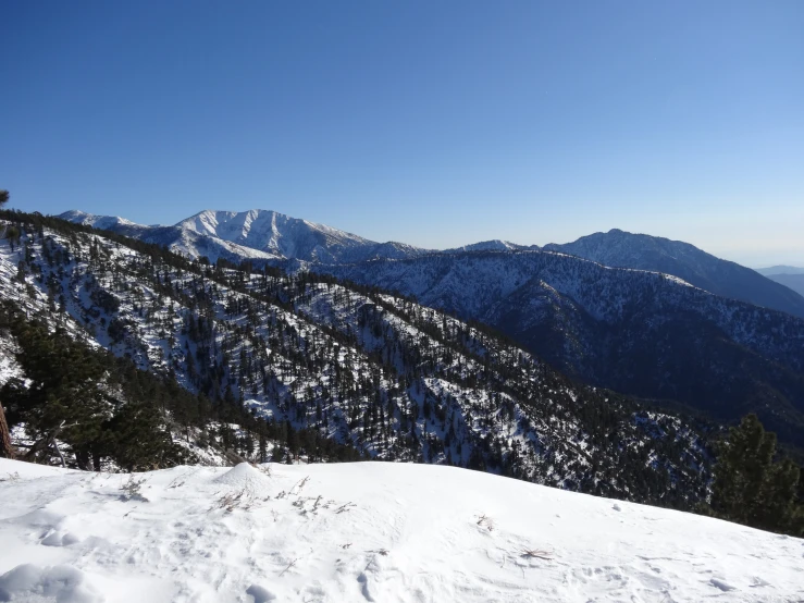 a snowy mountain view with the top of the mountains in the distance