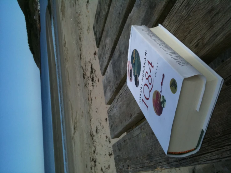 a paperback book laying on top of an old wooden table