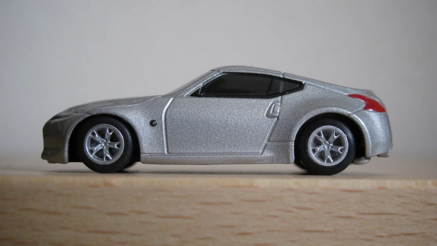 a metallic toy car with a white car logo on the back of it