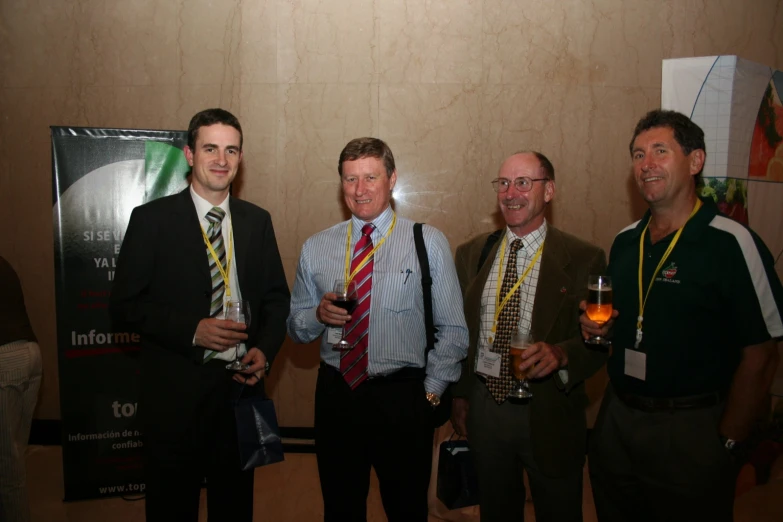 four men posing for a picture at a wine tasting