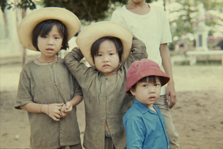 three children in hats pose for a po