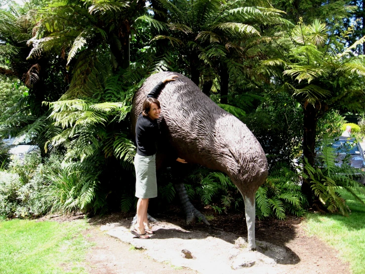 a man that is bending over near some vegetation