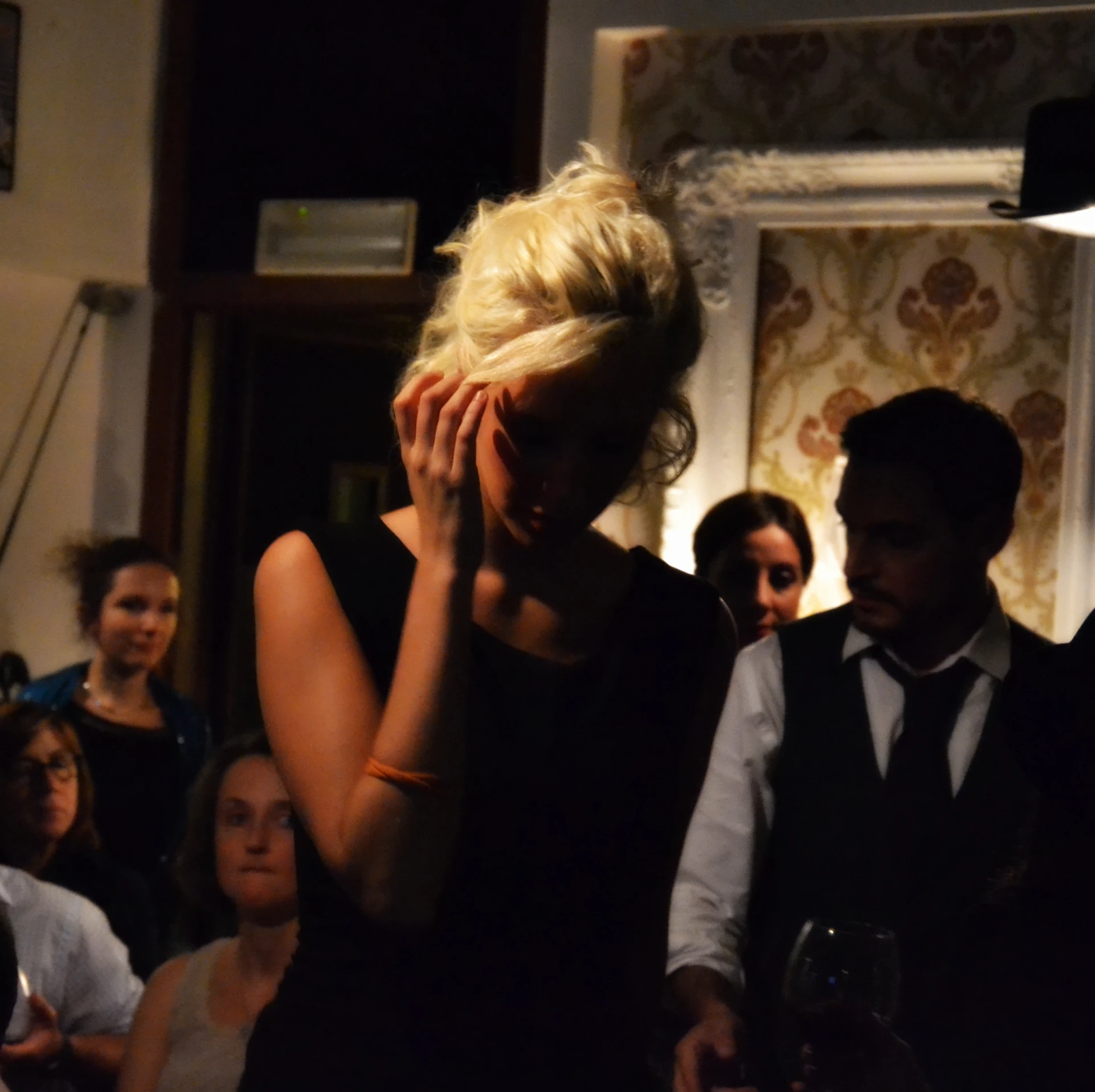 a beautiful blonde woman in a black dress at a party