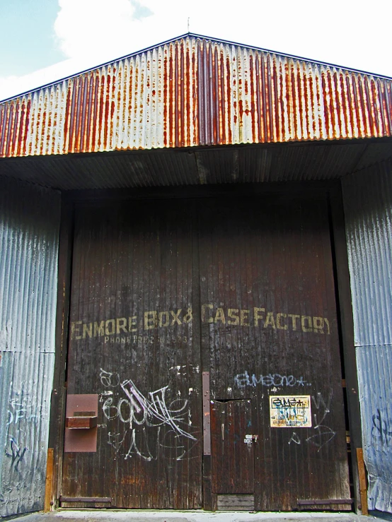 an entrance to a train tunnel with some graffitti on the doors