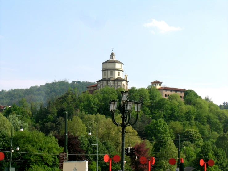 a lamp post next to a tree filled hillside