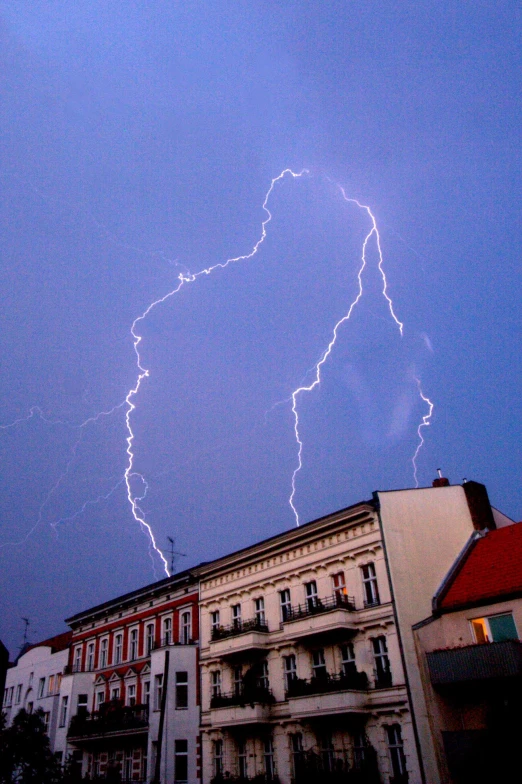 a lightning strike strikes over a city and buildings