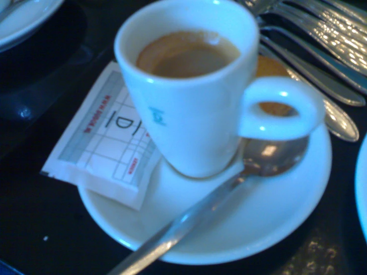 a coffee mug sits next to an empty spoon and fork