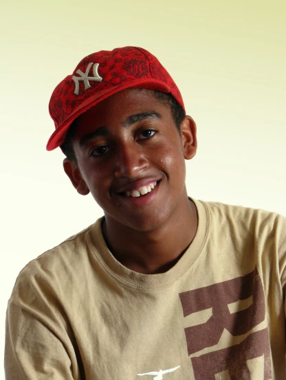 a young man is smiling wearing a baseball hat