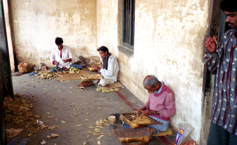 people sitting down on the ground next to a building